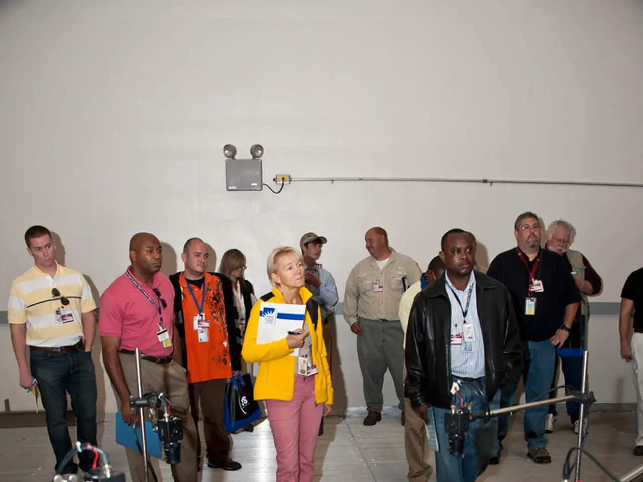 In the image there are a group of people standing on the floor in a room and in front of them there...