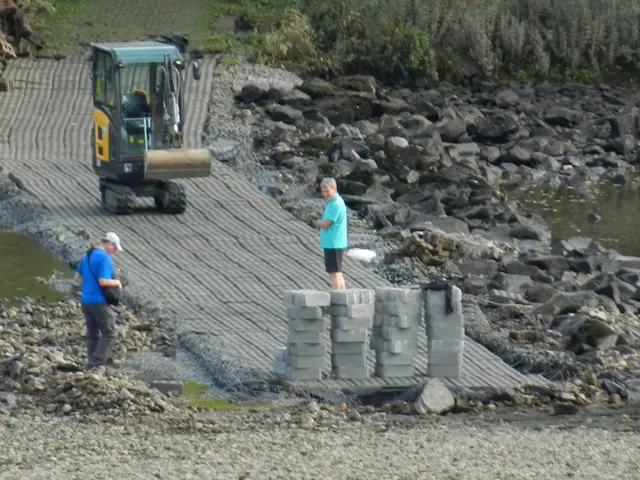 In this picture we can see there are people standing on the under construction road, behind them...