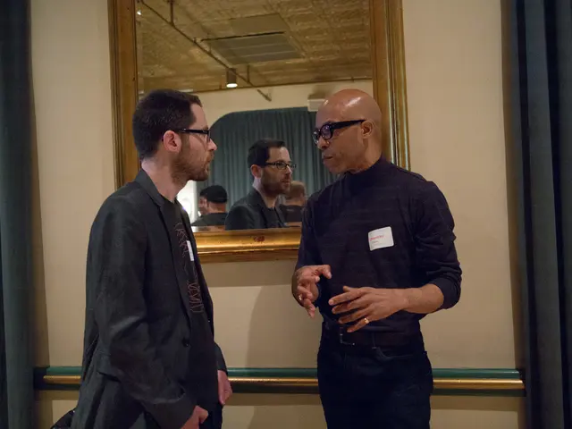 In this picture there is an African man wearing black color shirt and pant is talking with the...